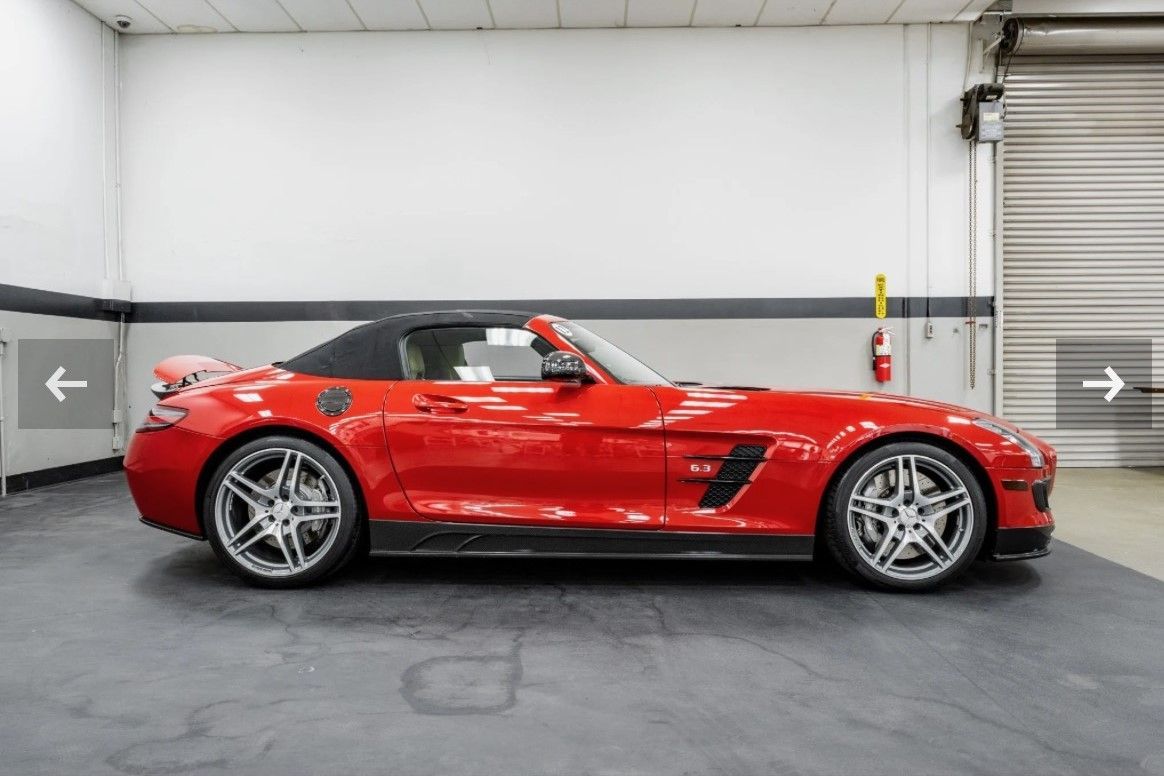 A red sports car is parked in a garage.