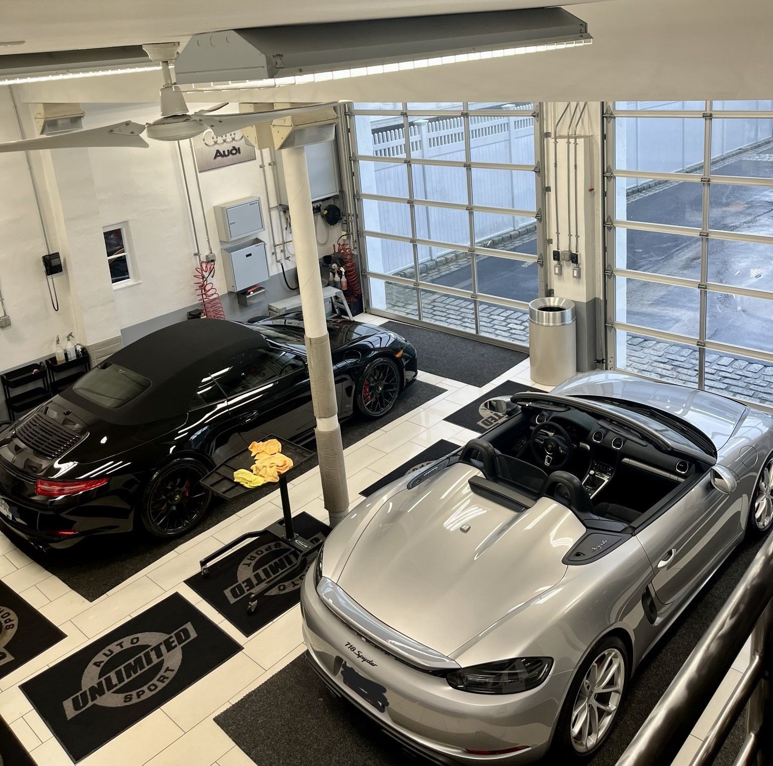 A couple of cars are parked in a garage.