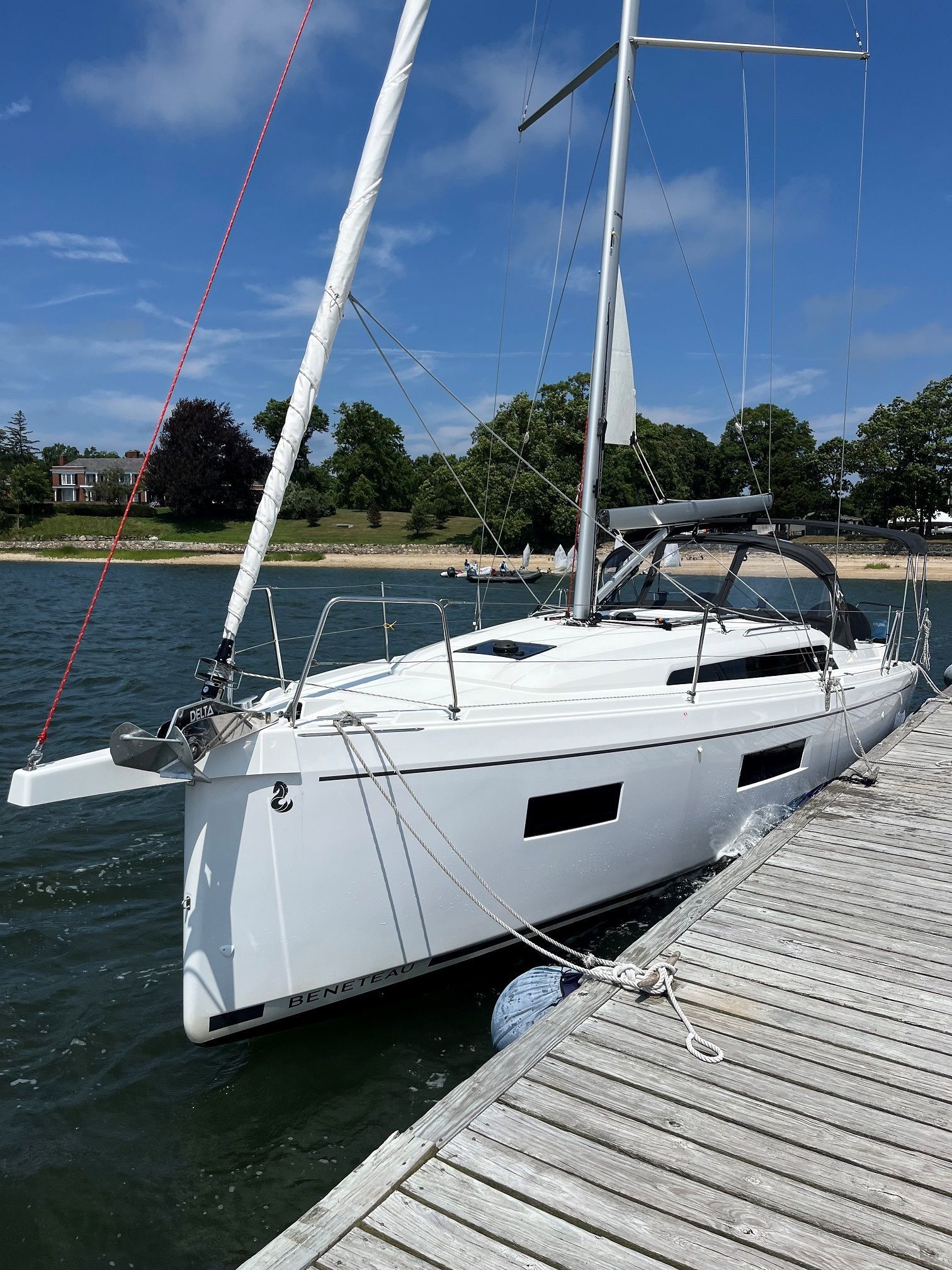 A white sailboat is docked at a dock in the water.