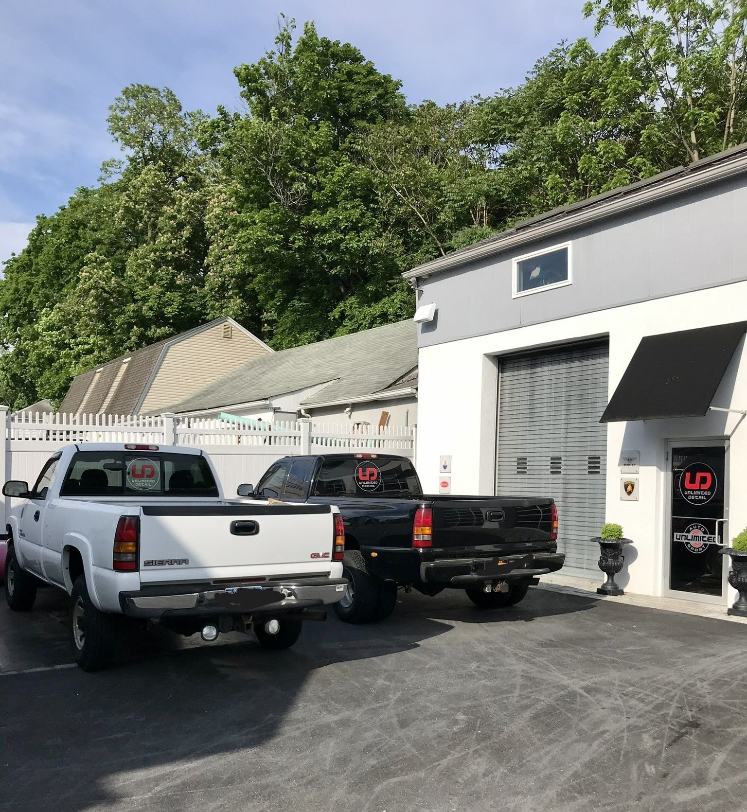 Two pickup trucks are parked in front of a garage