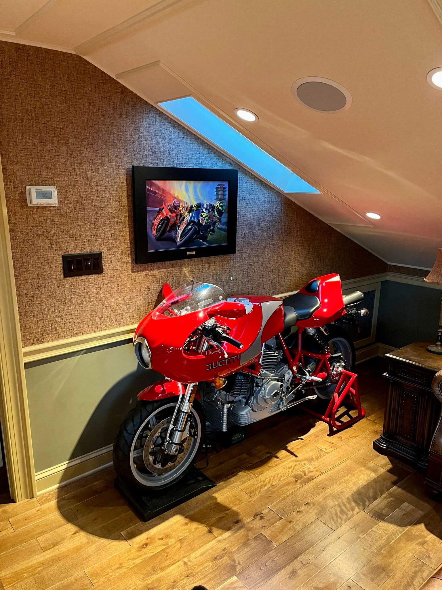 a red motorcycle is parked in a room next to a television