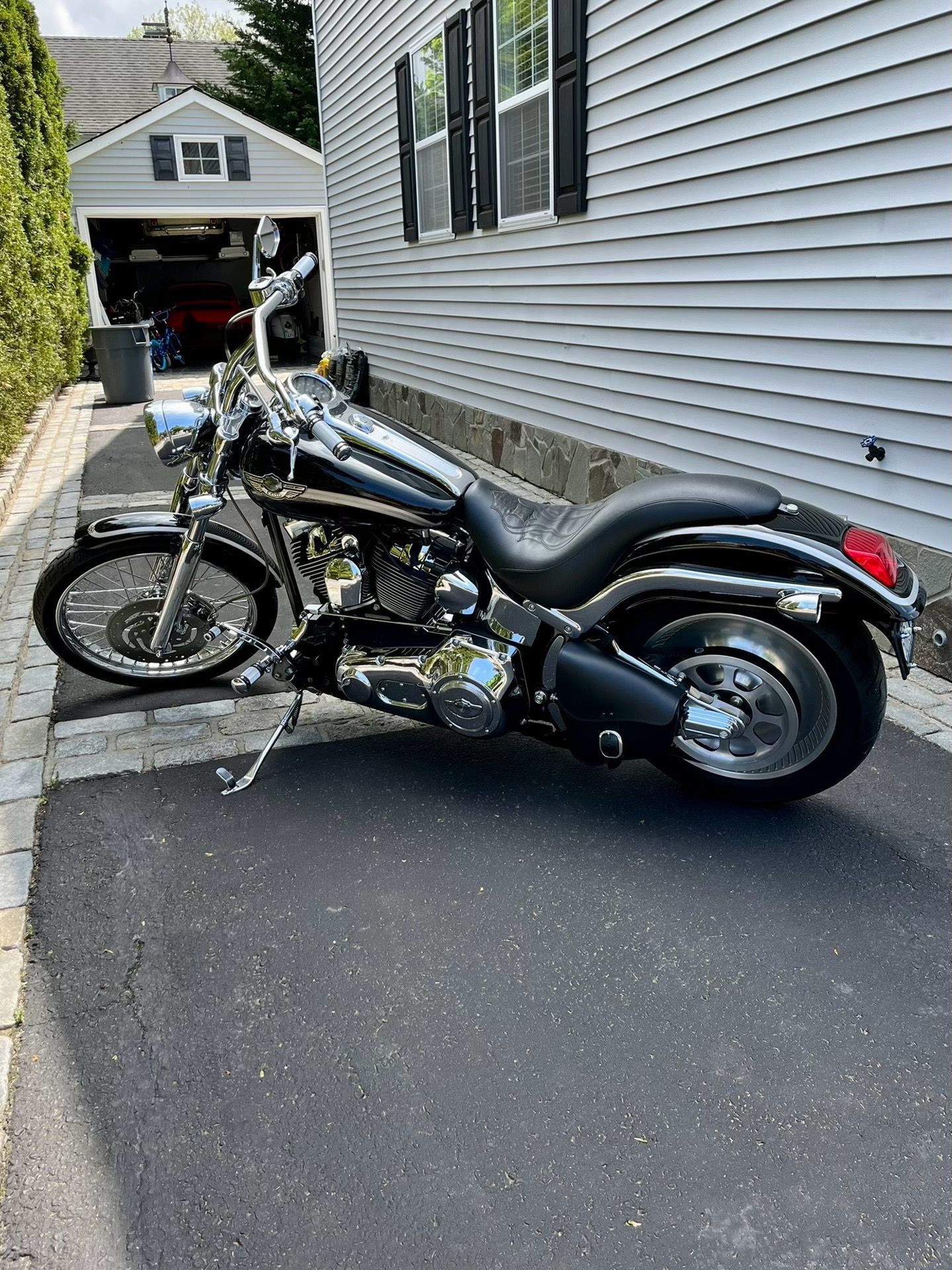 a motorcycle is parked on the side of the road in front of a house