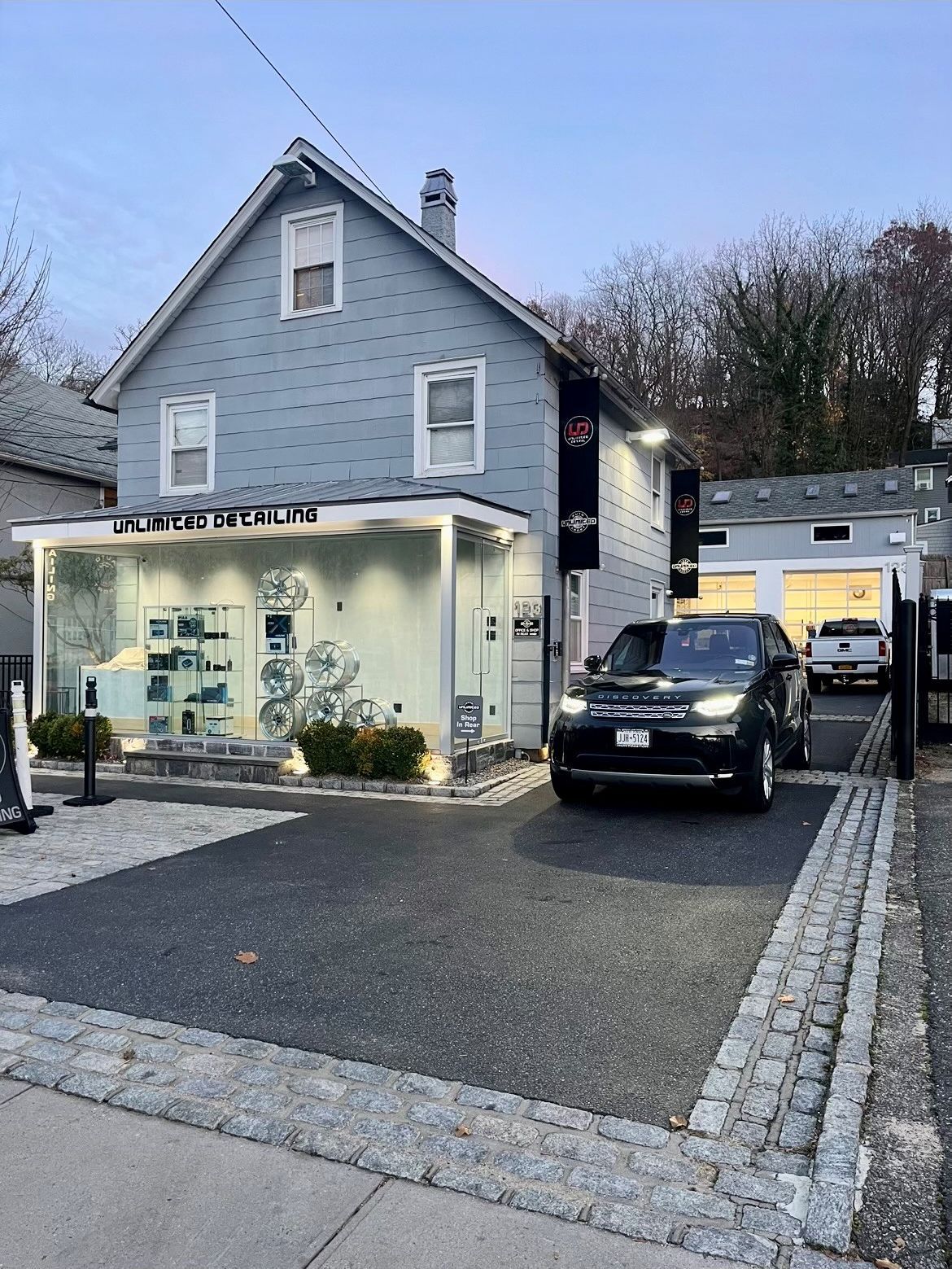 A black range rover is parked in front of a grey building.