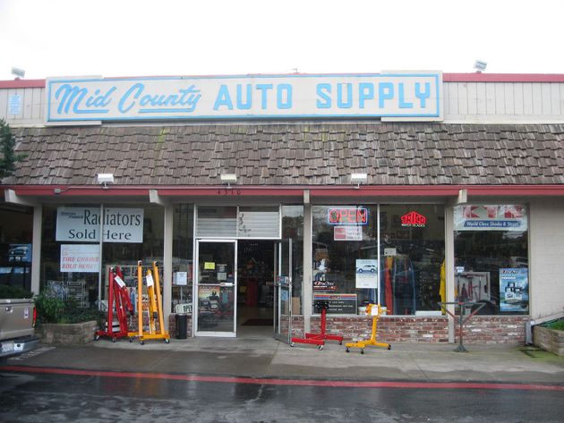 Auto supply store storefront with blue and white sign and shopping carts outside
