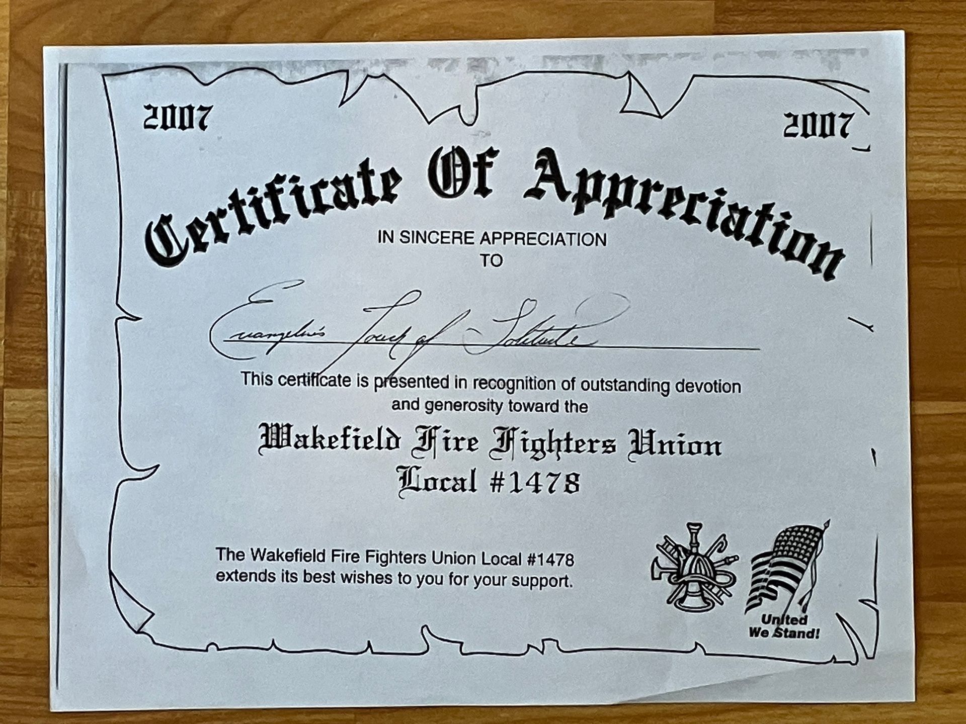 Framed certificate of appreciation with decorative border, displayed on a wall.