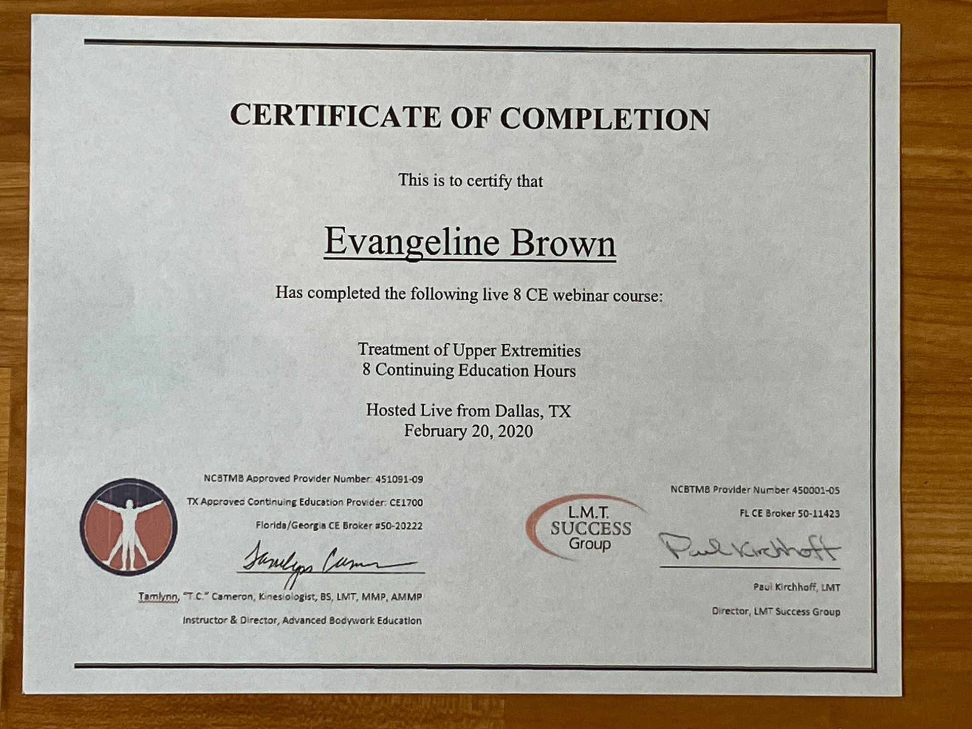 Certificate of completion for Kyrgeline Brown, displayed on a wall with signatures and seals