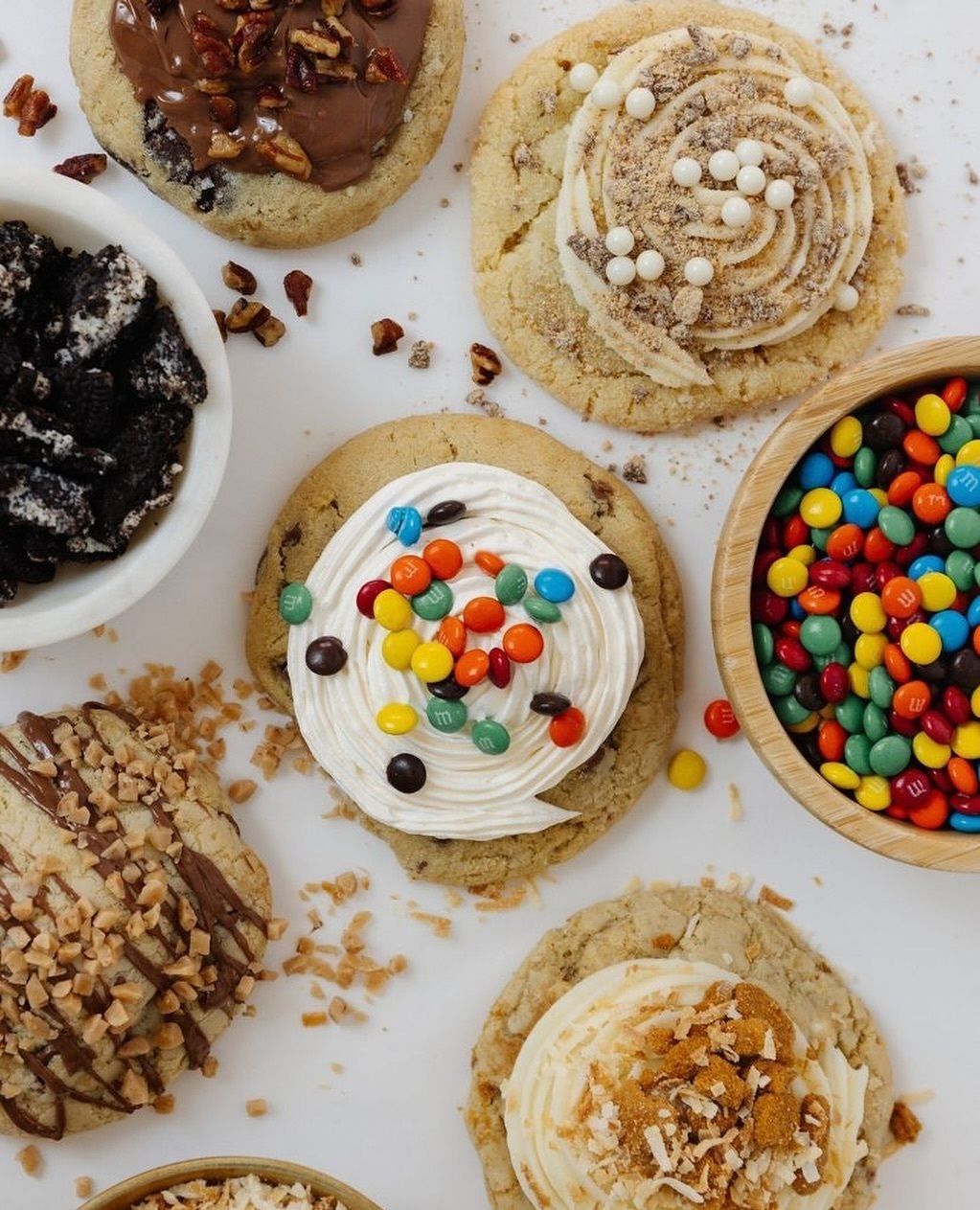 A variety of cookies and bowls of candy on a table