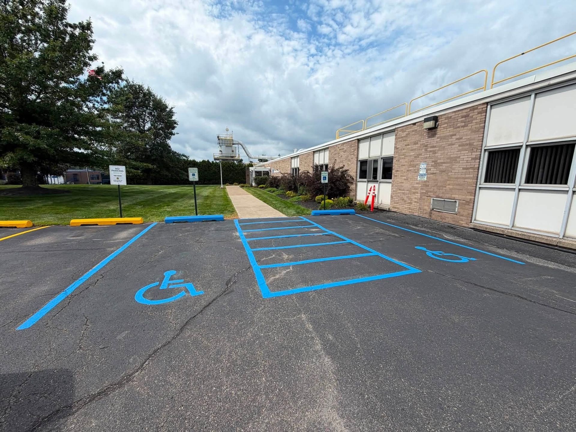 Parking lot with blue-marked accessible spaces beside a brick building