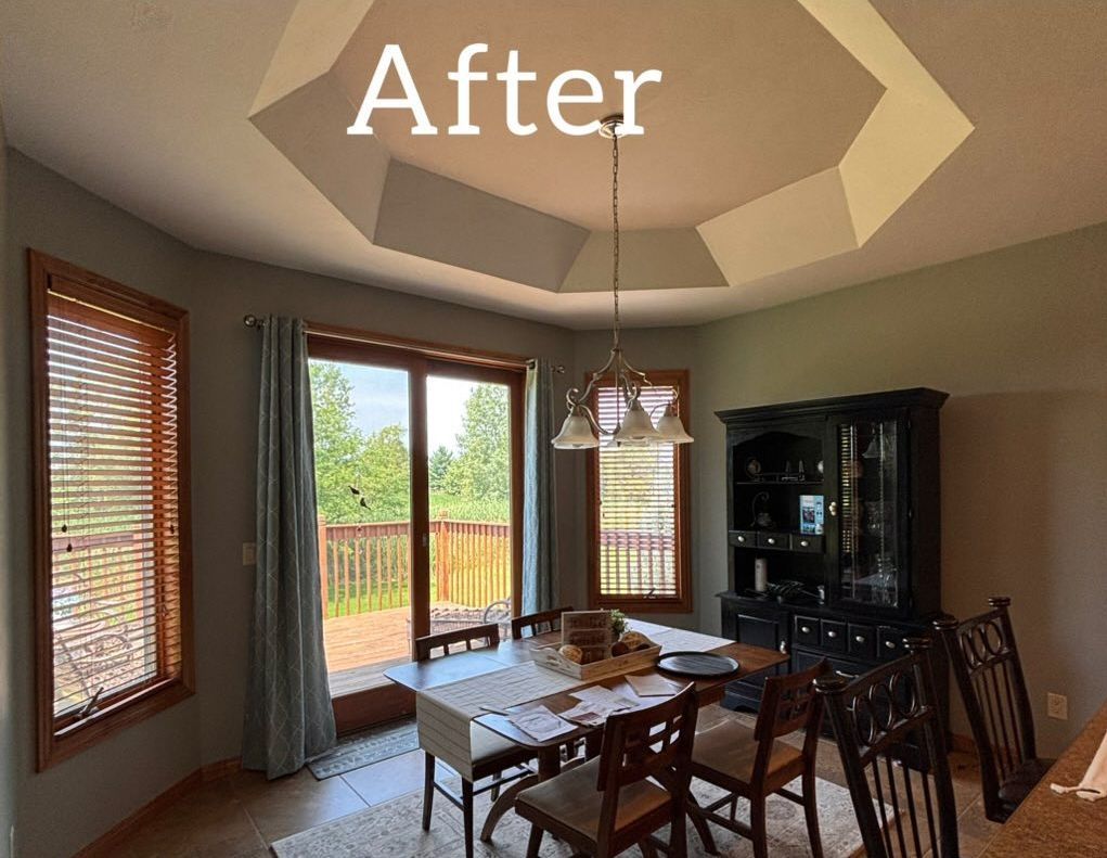 Dining room with a wood table, a black hutch, a chandelier, and an octagonal ceiling feature. - after