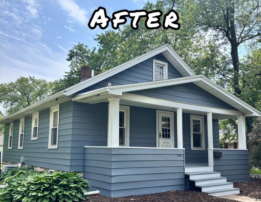 A light green house with white trim and a porch. - after