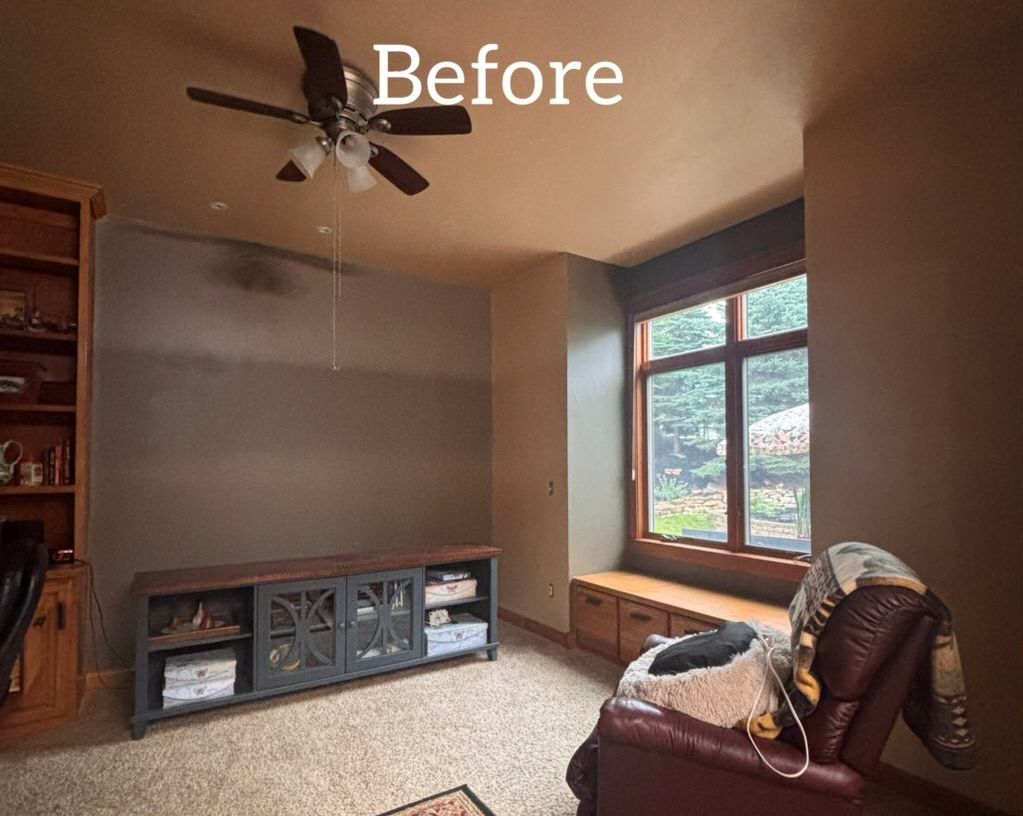 A room with a brown ceiling and walls, a window, and a cabinet - before