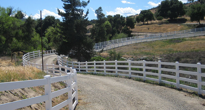 A long road with a wooden fence