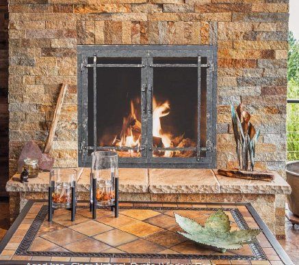 There is a fireplace in the middle of the room with a table in front of it.