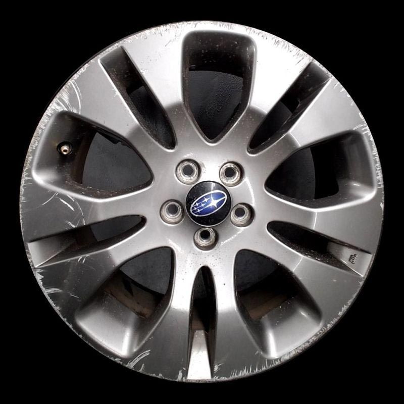 A close up of a subaru wheel on a black background