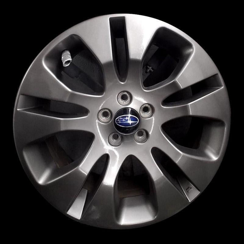 A close up of a subaru wheel on a black background