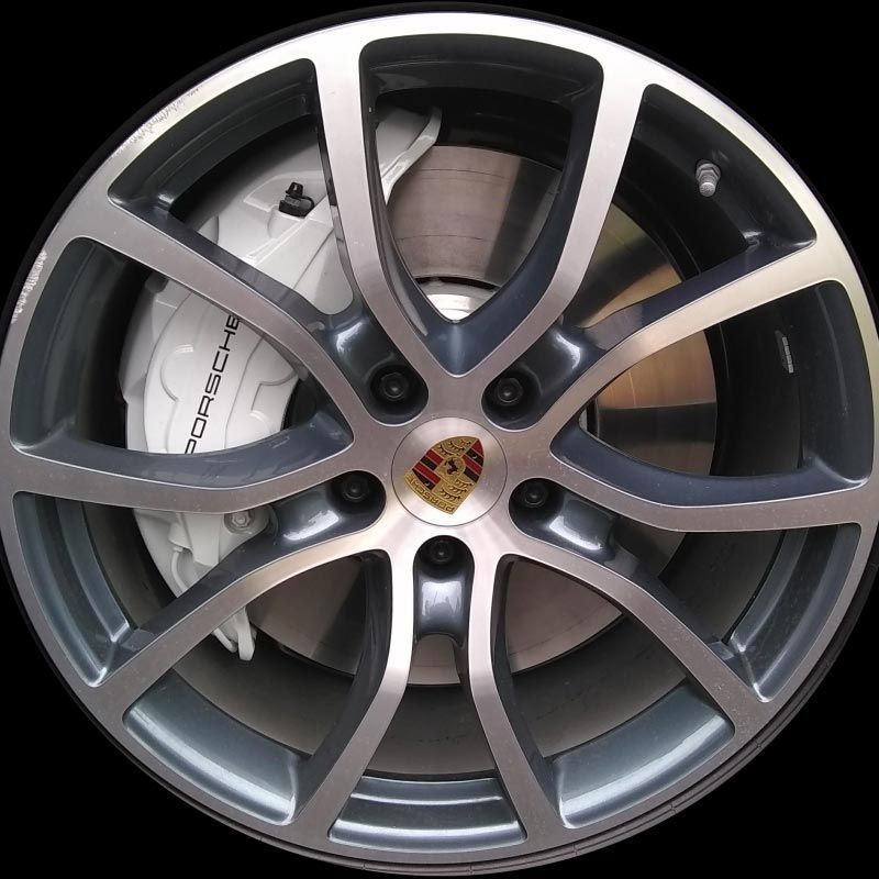 A close up of a porsche wheel with a white brake