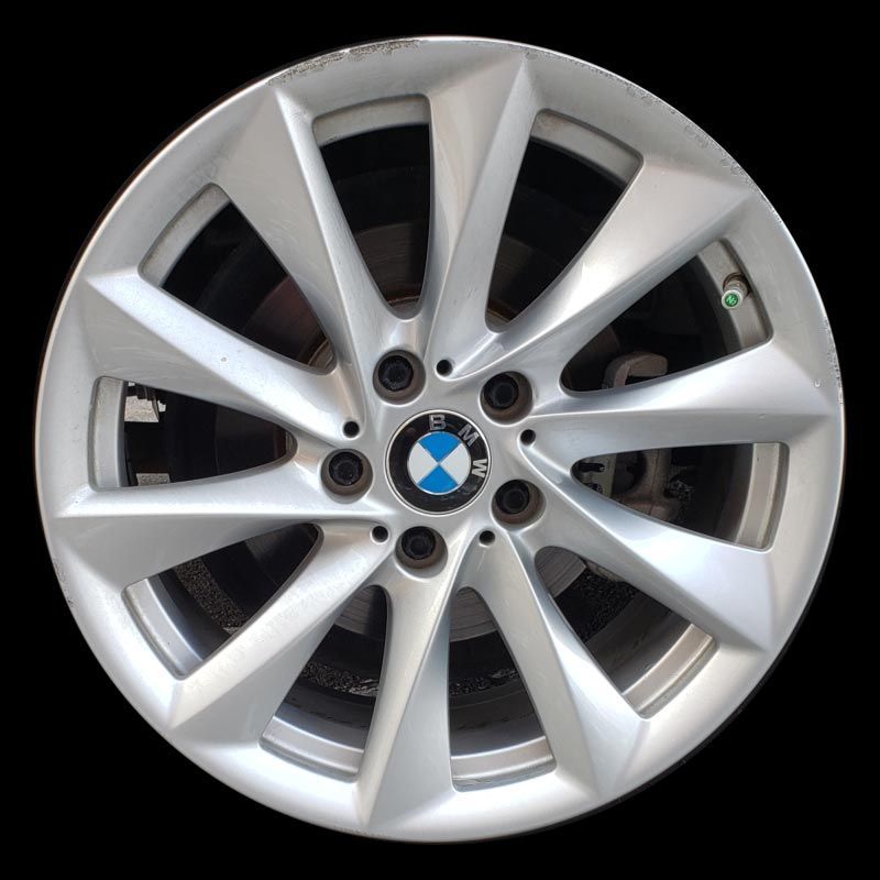 A close up of a bmw wheel on a black background