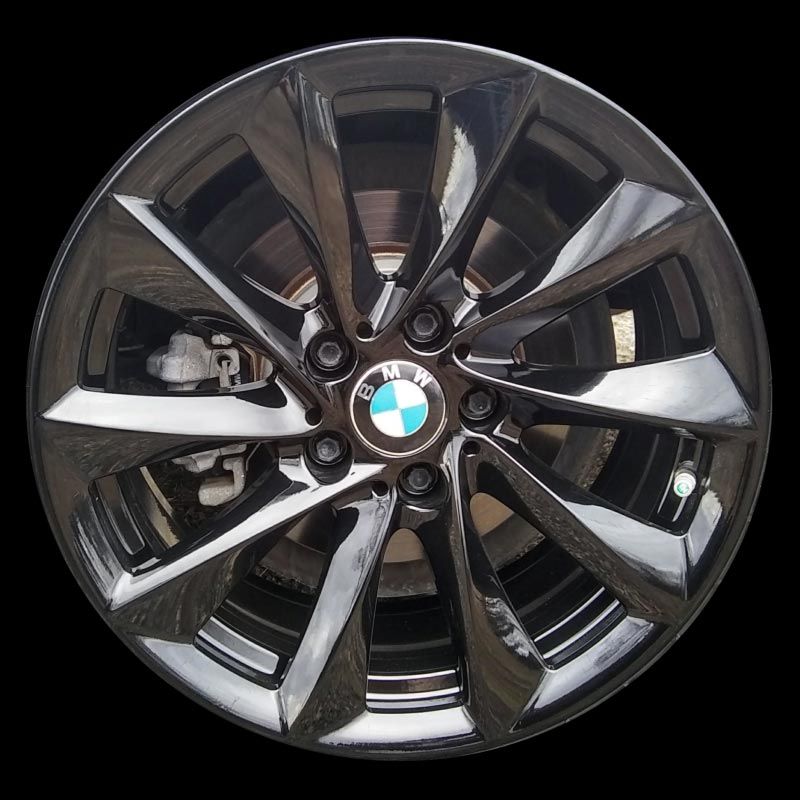 A close up of a bmw wheel on a black background