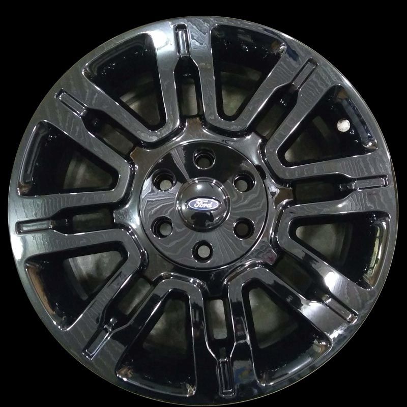 A close up of a ford wheel on a black background