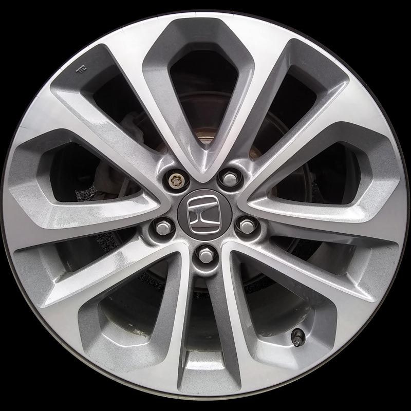 A close up of a honda wheel on a black background