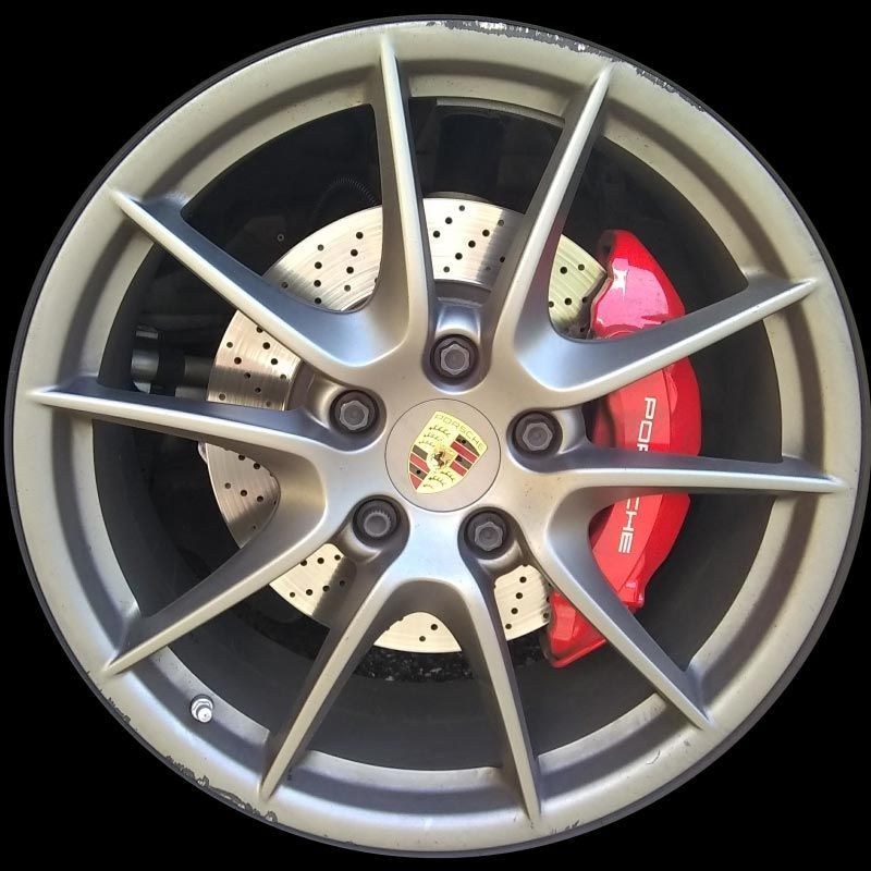 A close up of a porsche wheel with a red brake