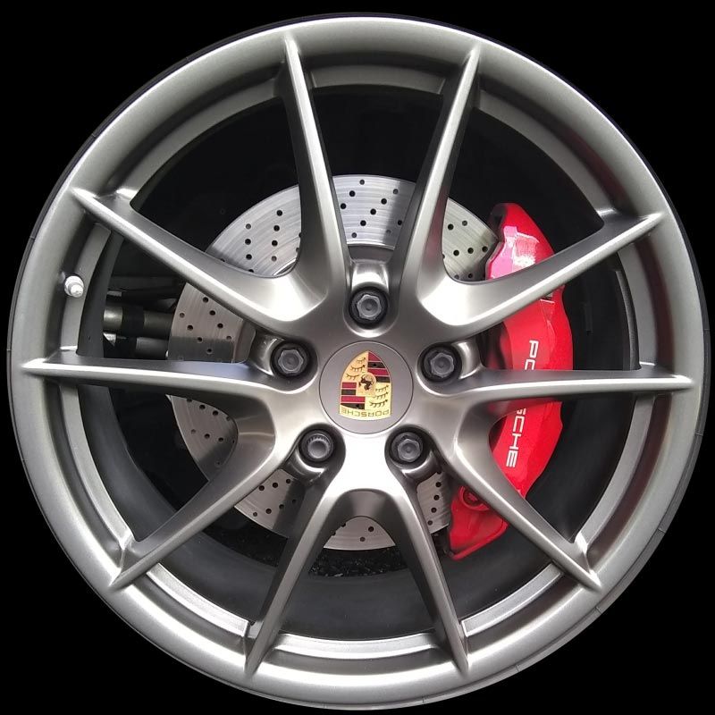 A close up of a porsche wheel with a red brake