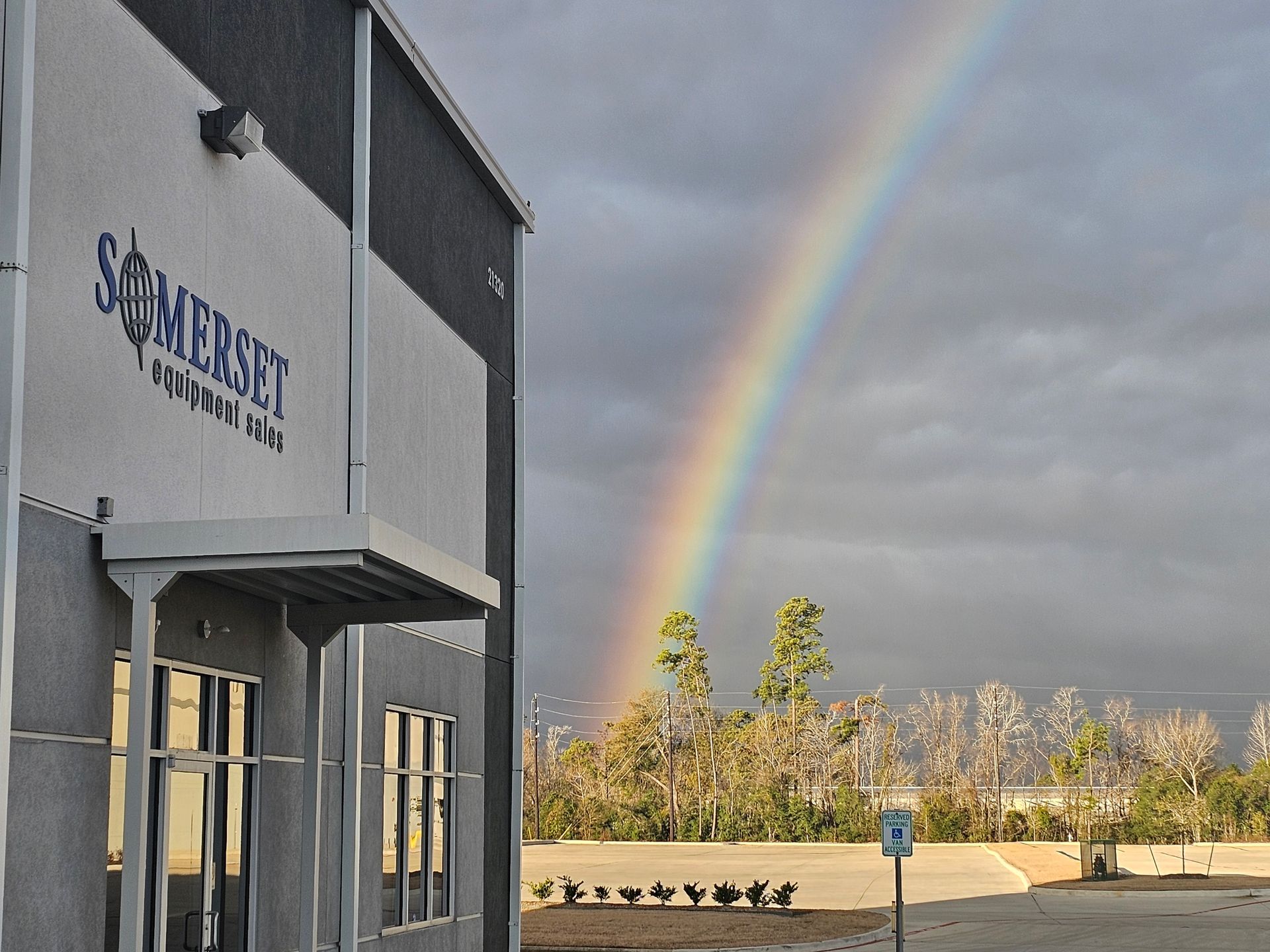 Three forklifts inside a warehouse: yellow, black, and green.