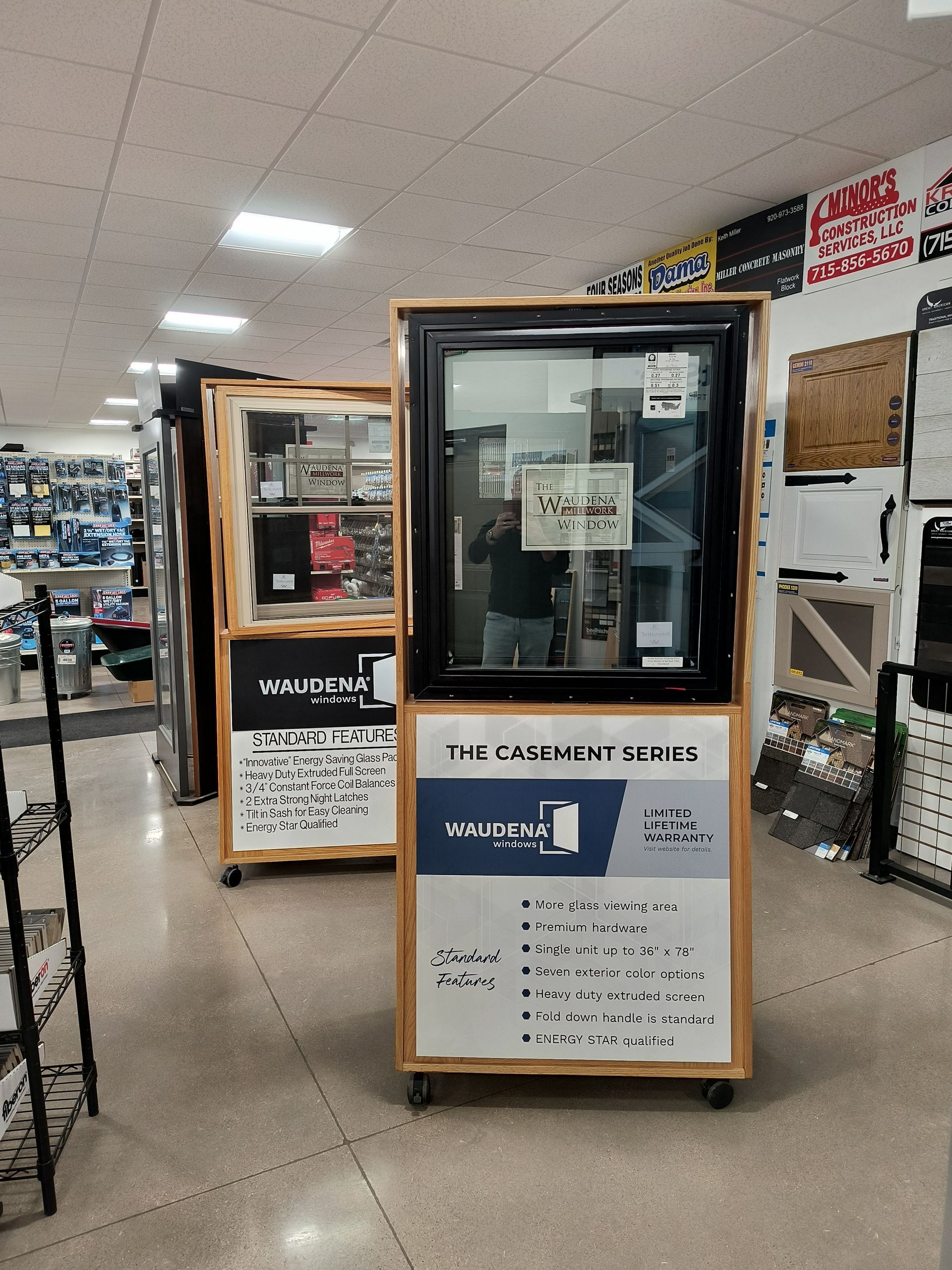 Two window displays on wheels in a store. One has a black window frame, the other has a tan frame.