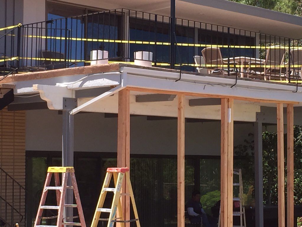 A house under construction with a balcony and ladder