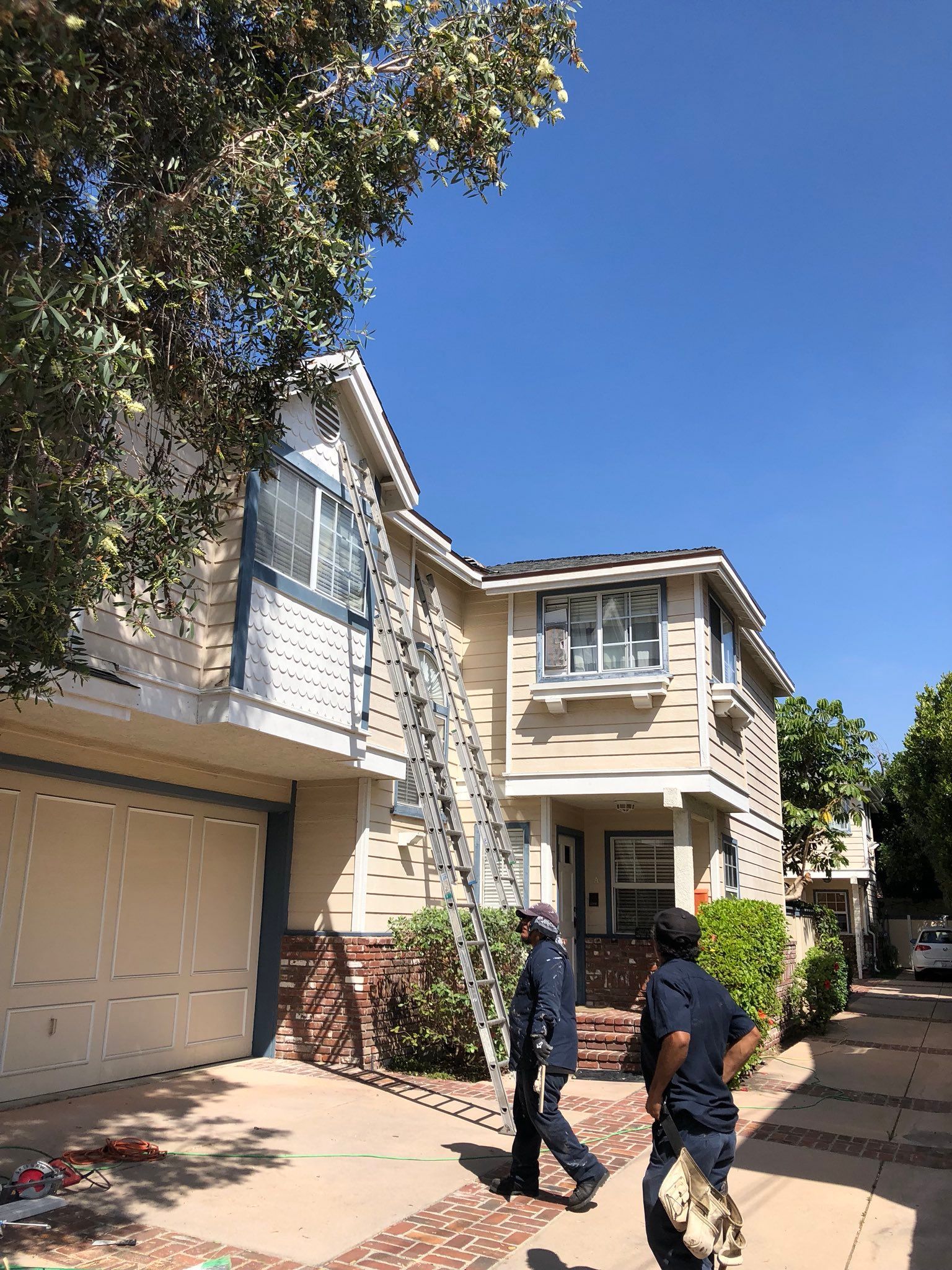 A couple of men are standing in front of a house.