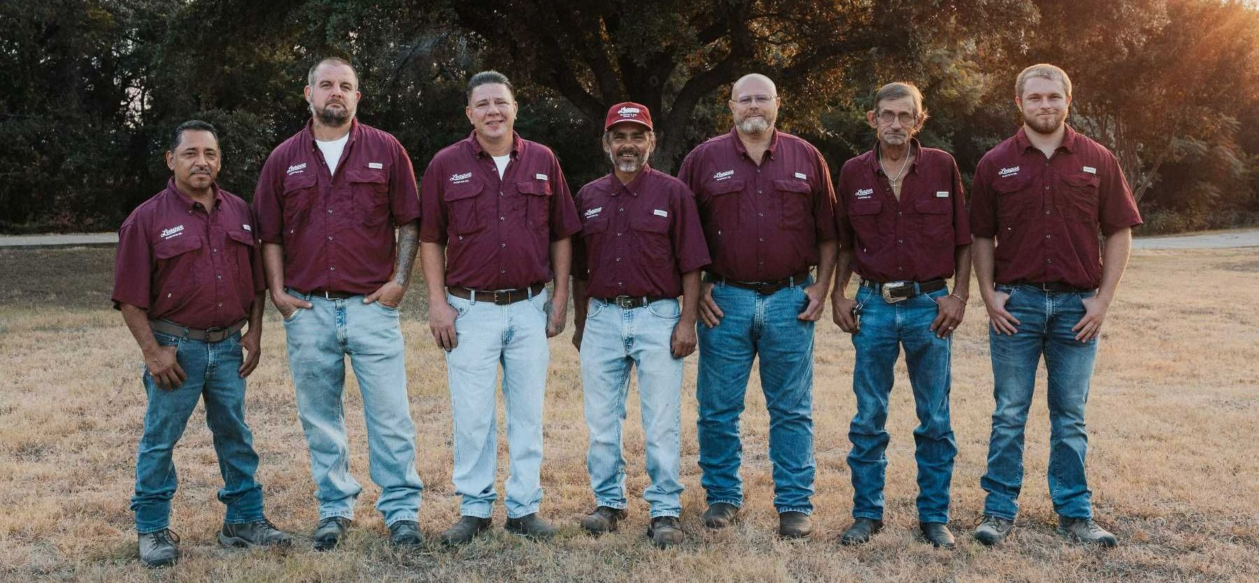 A group of men standing next to each other in a field.