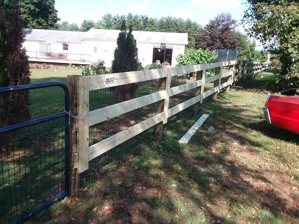A wooden fence with a red car parked in front of it