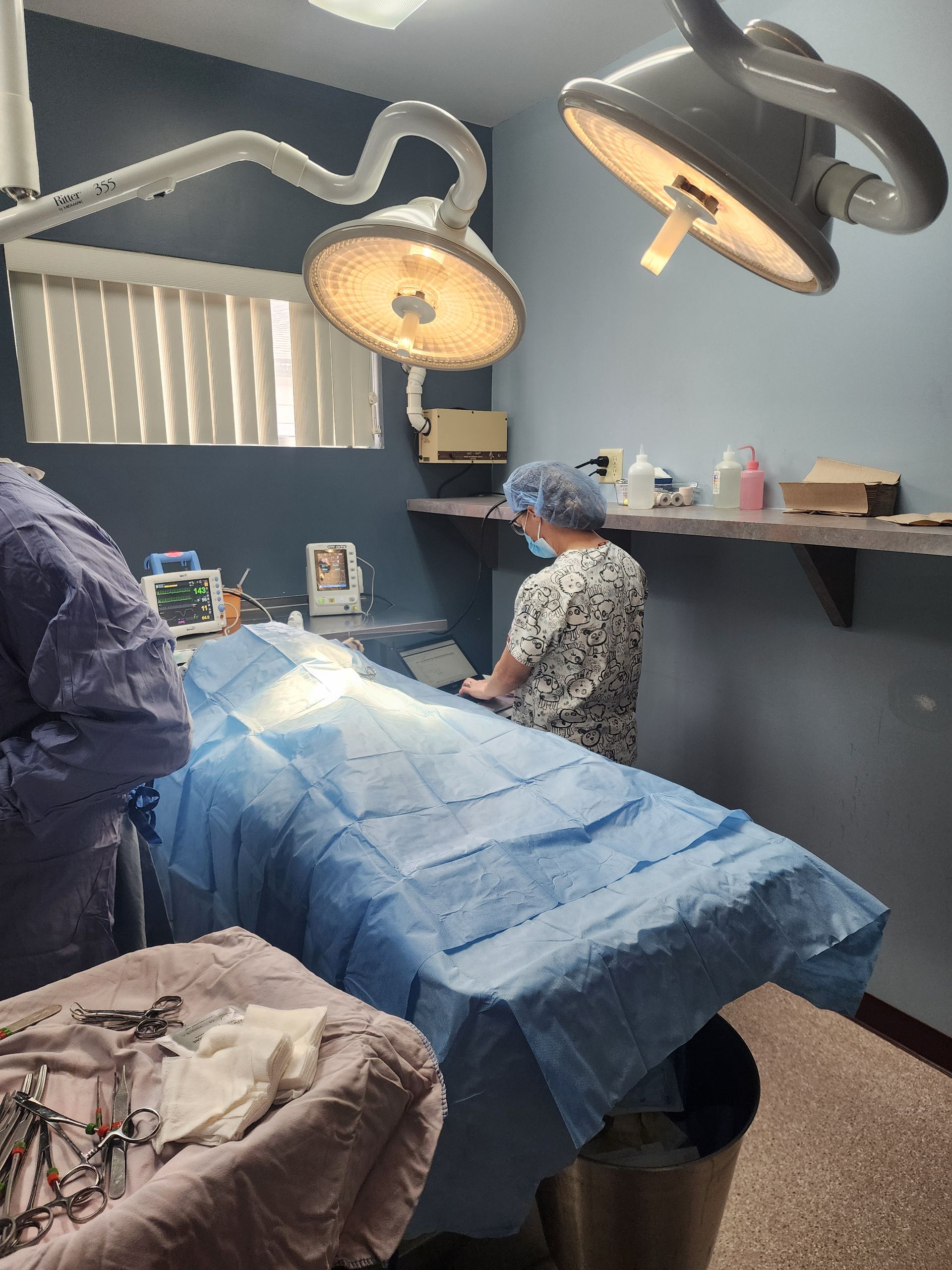 A surgeon is working on a patient in an operating room.