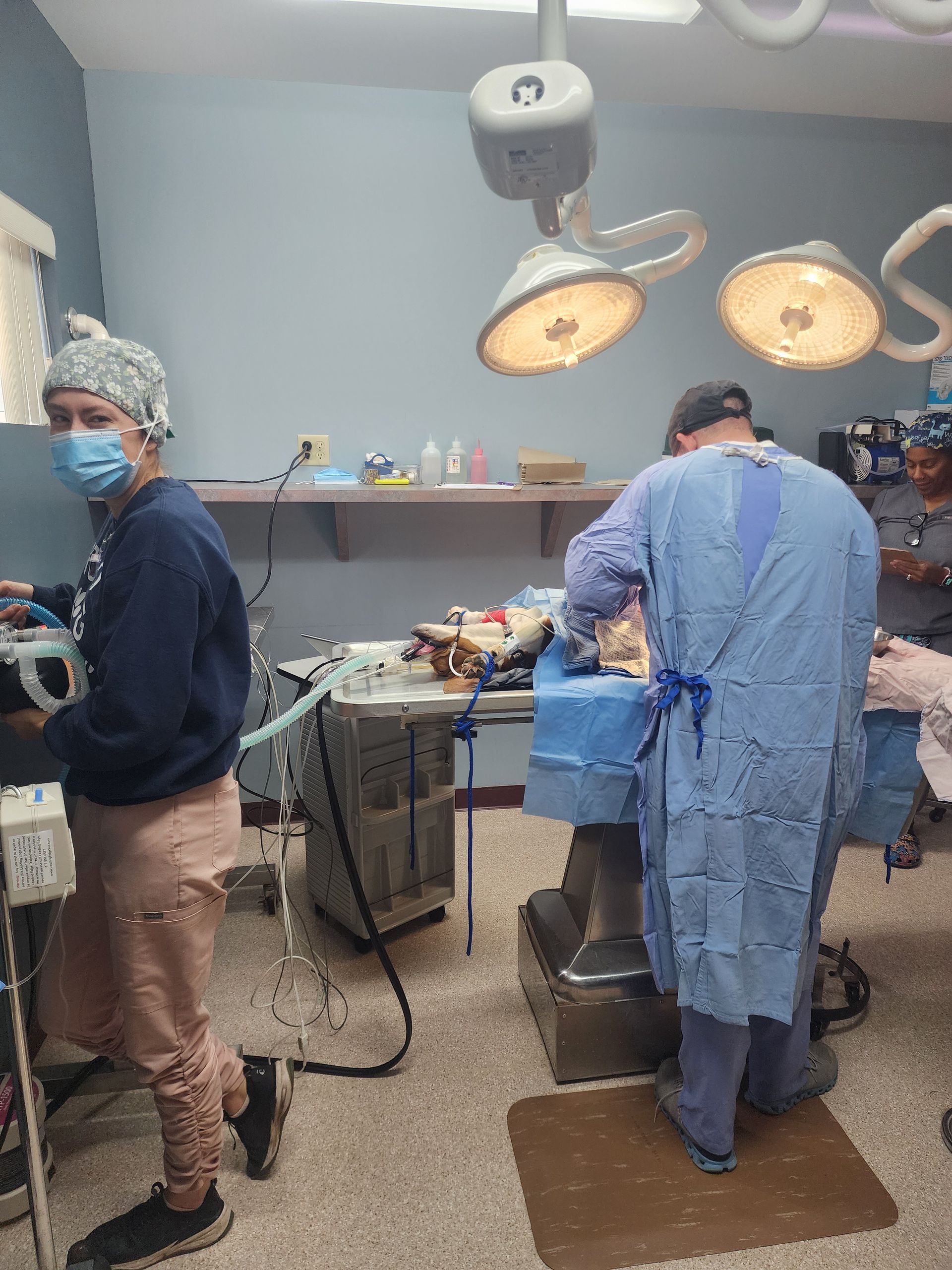 A group of surgeons are operating on a patient in an operating room.
