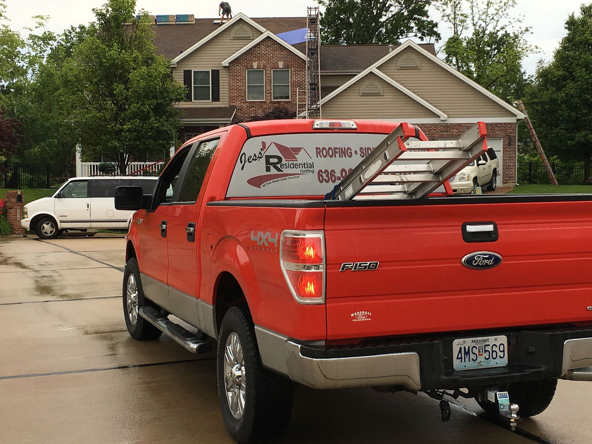 A red truck is parked in front of a house.
