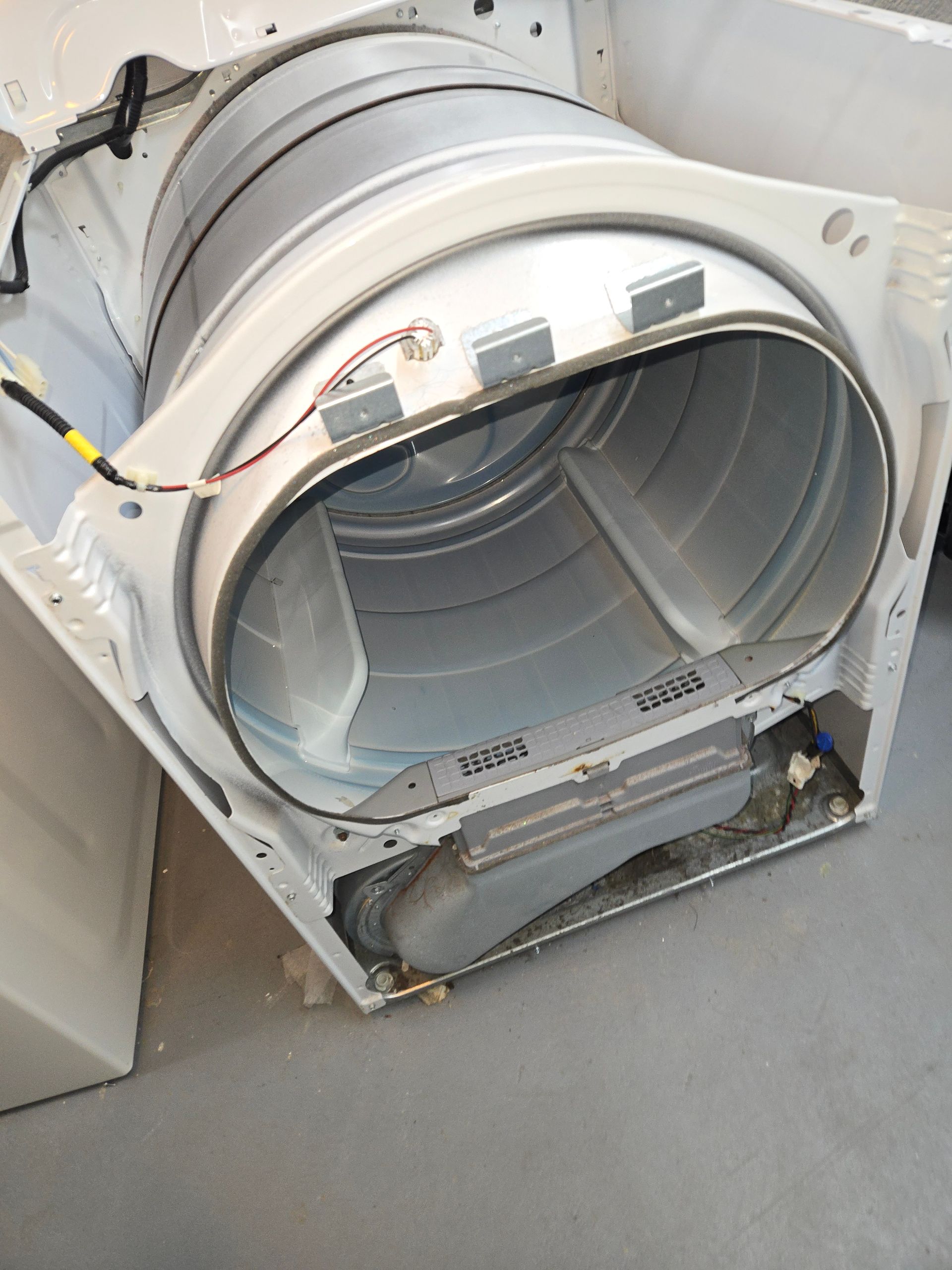 Open dryer front panel with the drum exposed and the lower compartment removed.