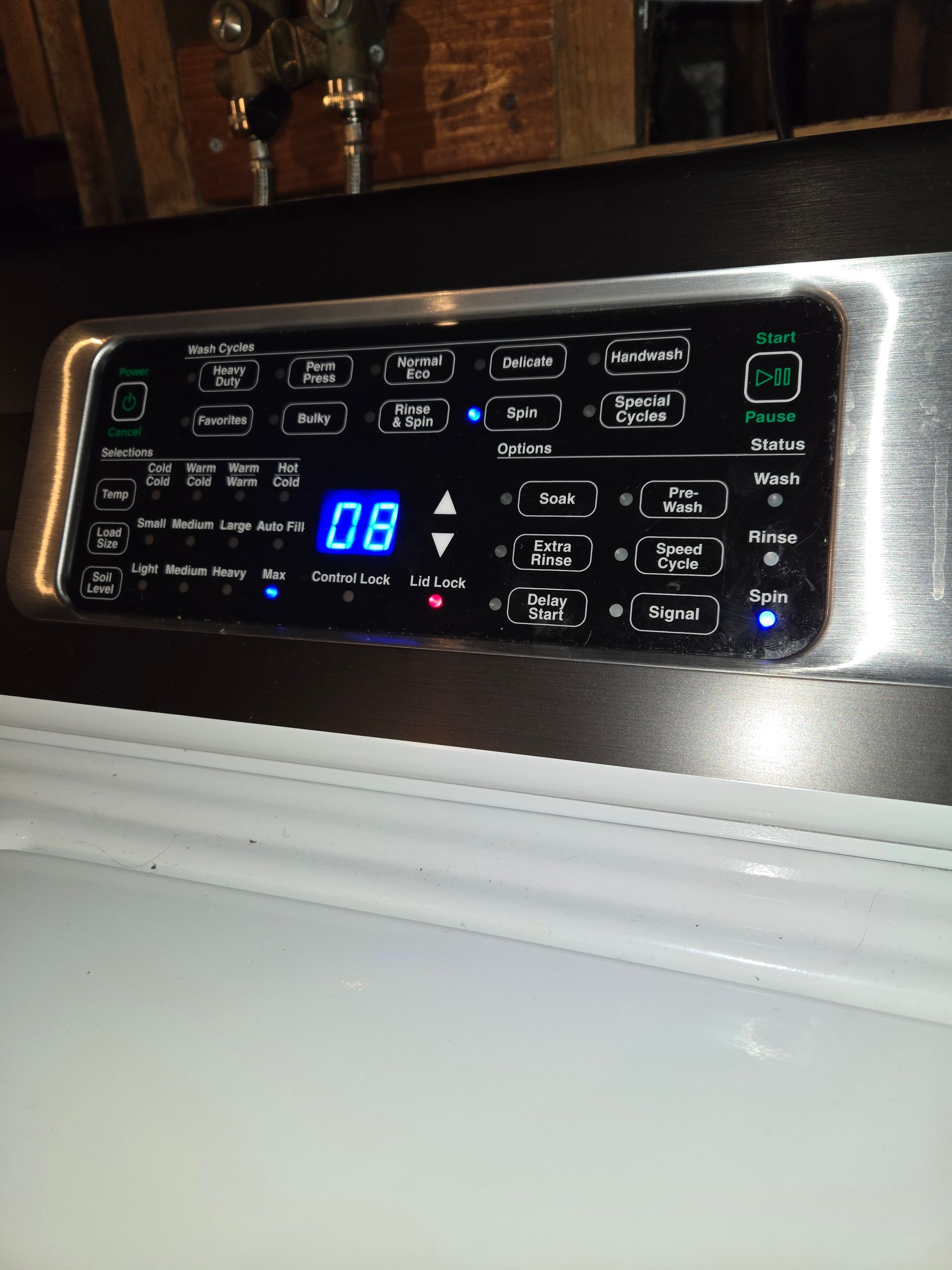 Close-up of a black stove control panel with blue digital display reading 08 and illuminated buttons.