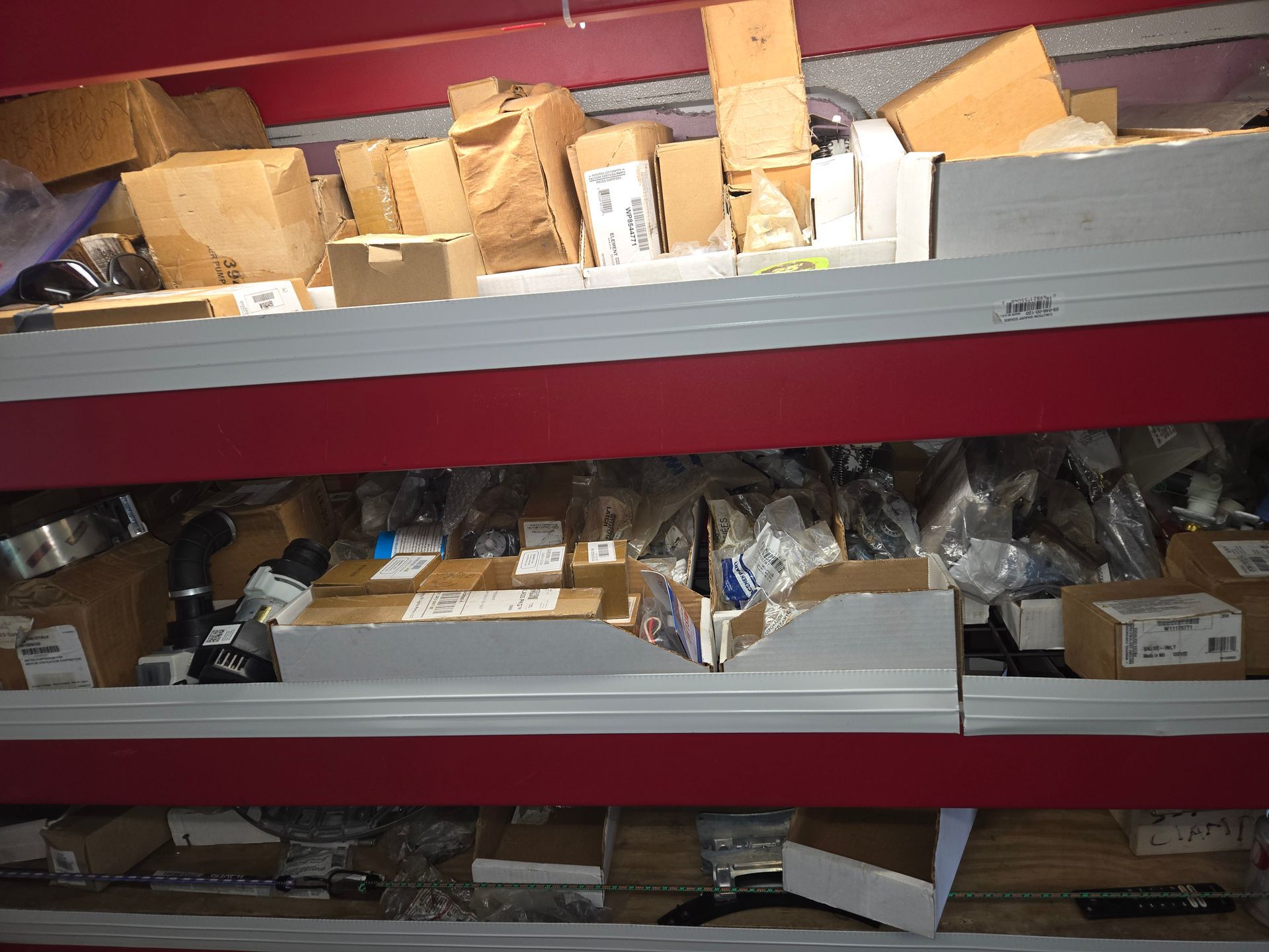 Warehouse shelves cluttered with assorted boxes, wrapped packages, and wooden blocks.