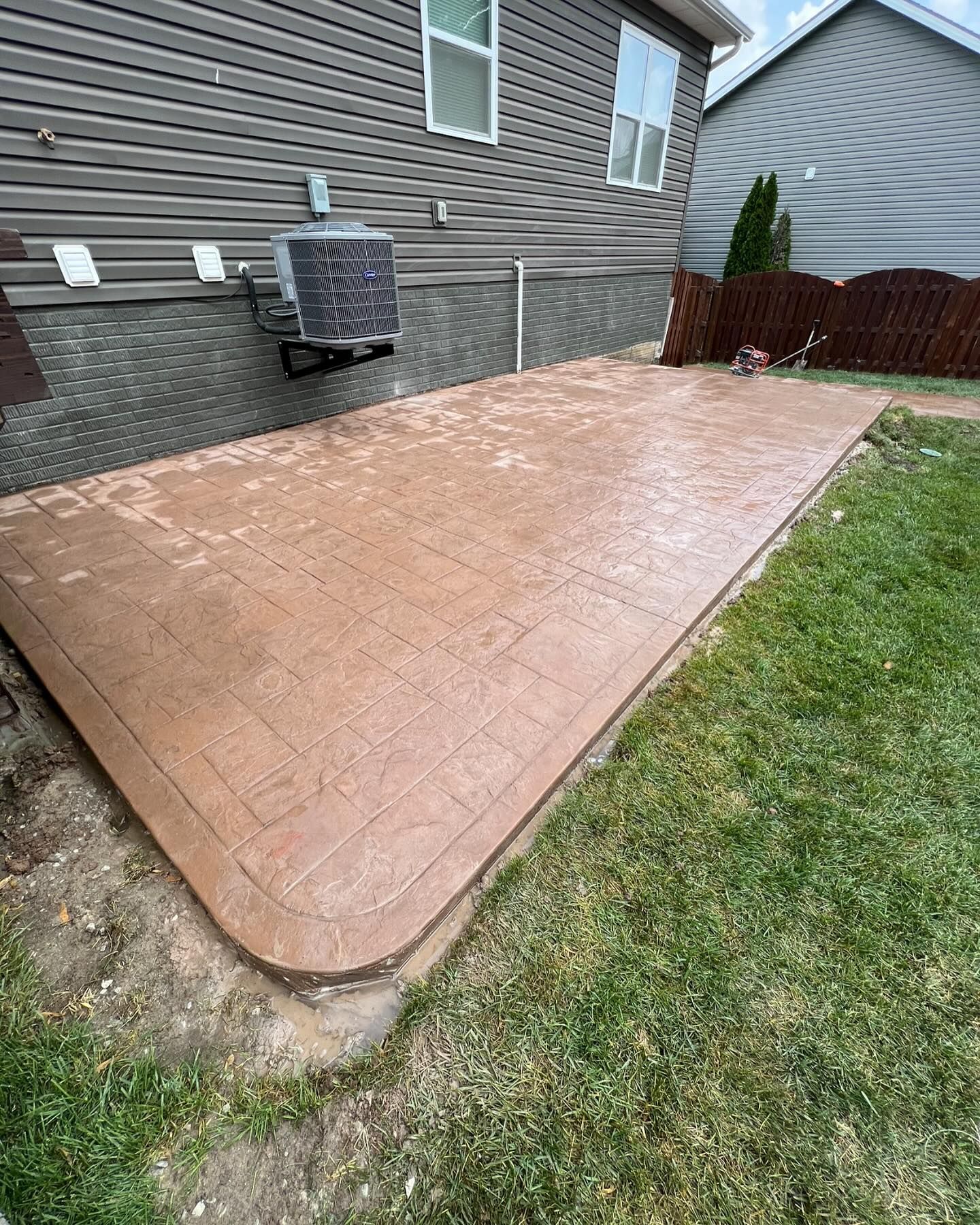 A concrete patio in the backyard of a house.