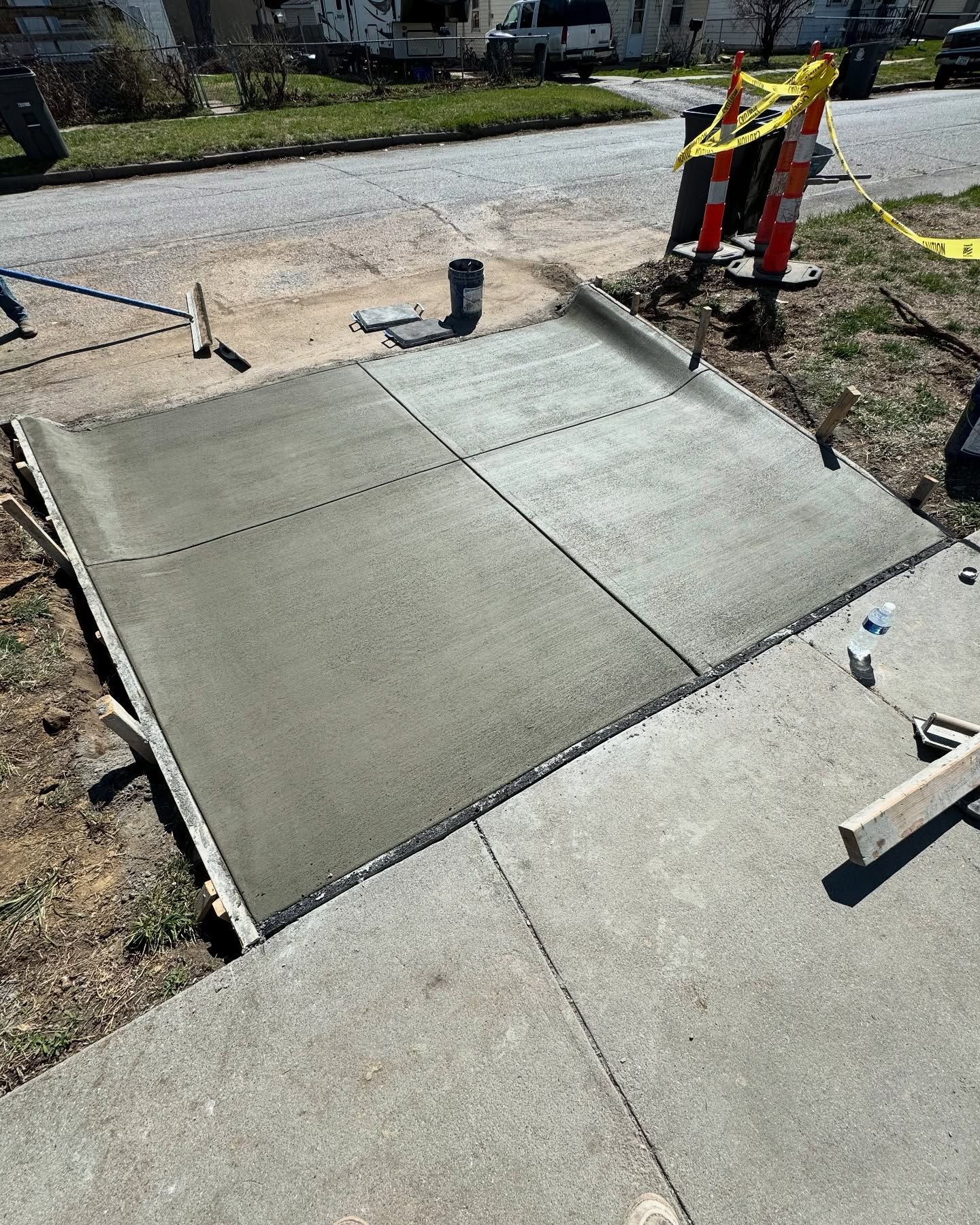 A concrete walkway is being built on the side of the road.