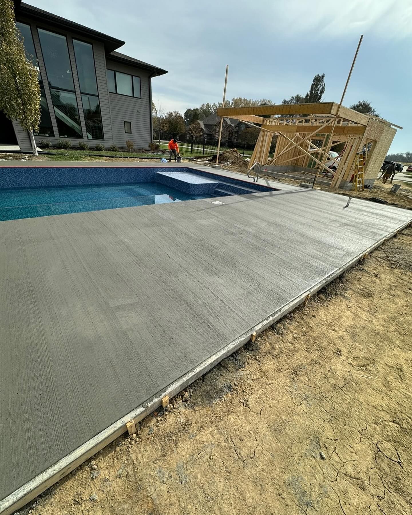 A swimming pool is being built in the backyard of a house.