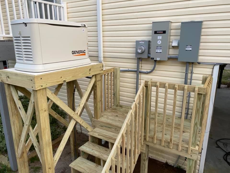 A generator is sitting on top of a wooden platform next to stairs.