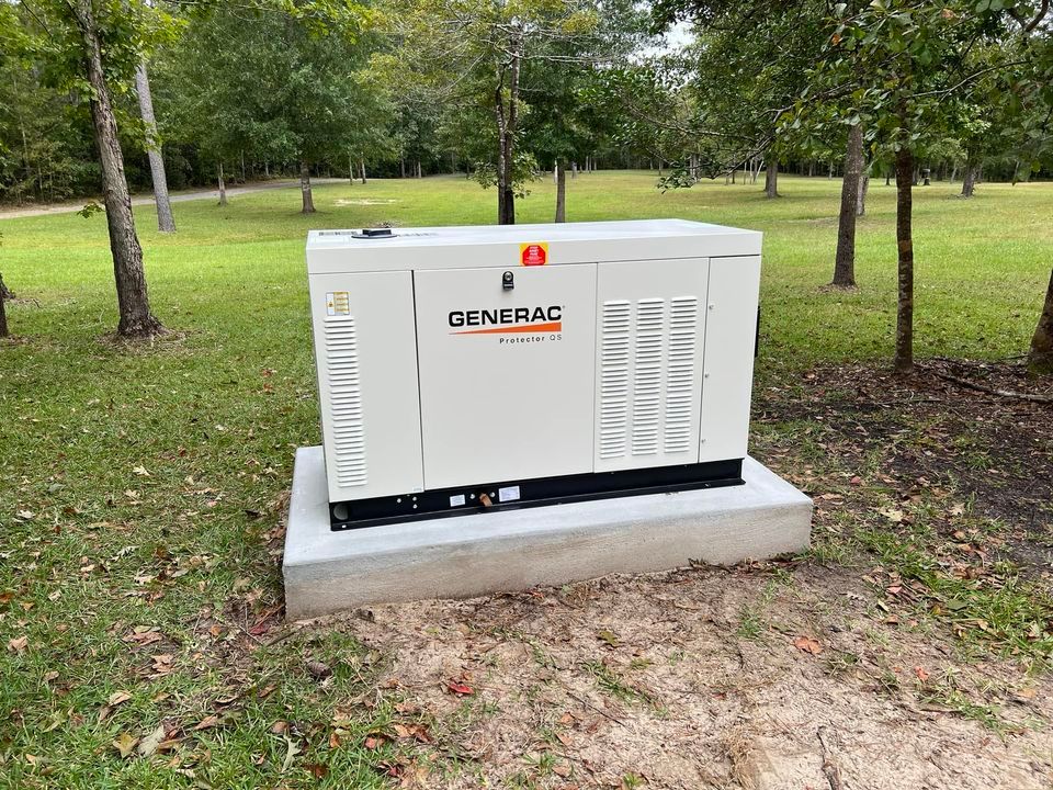 A generator is sitting in the middle of a grassy field.
