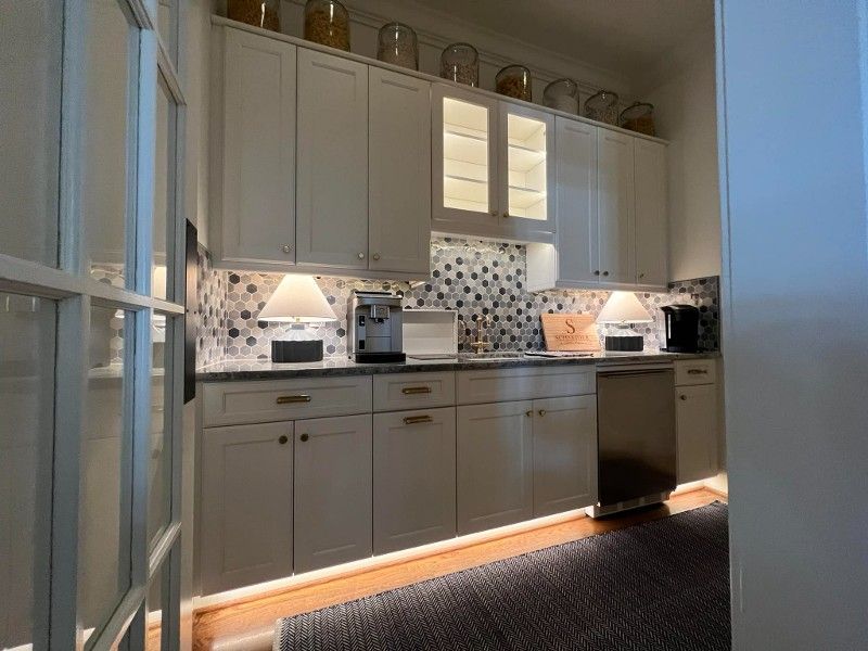 A kitchen with white cabinets and stainless steel appliances.