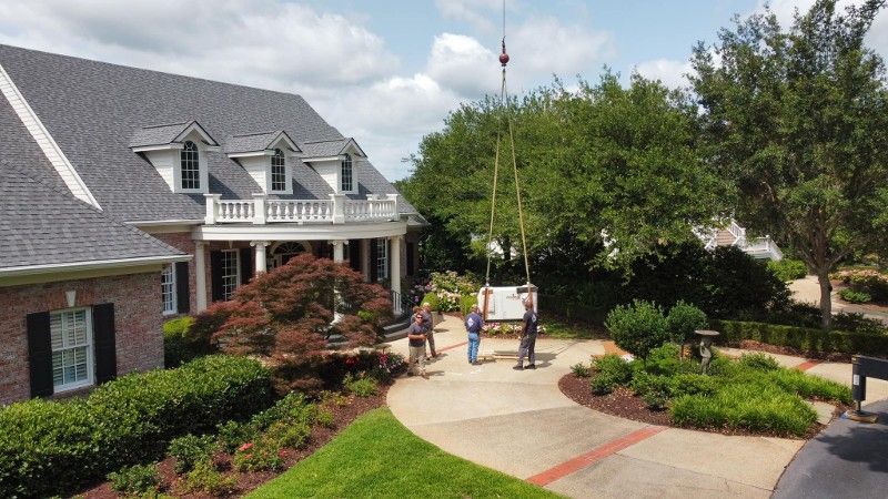 A group of people are standing in front of a large house.