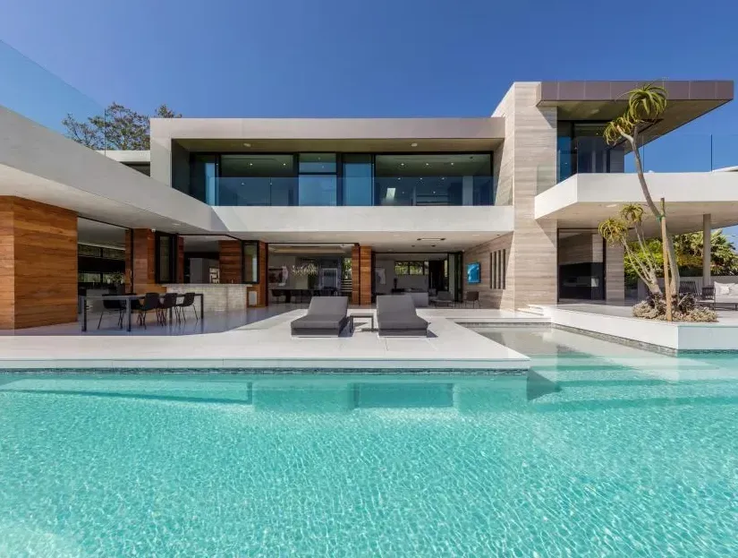 Modern luxury home with pool and outdoor lounge area.