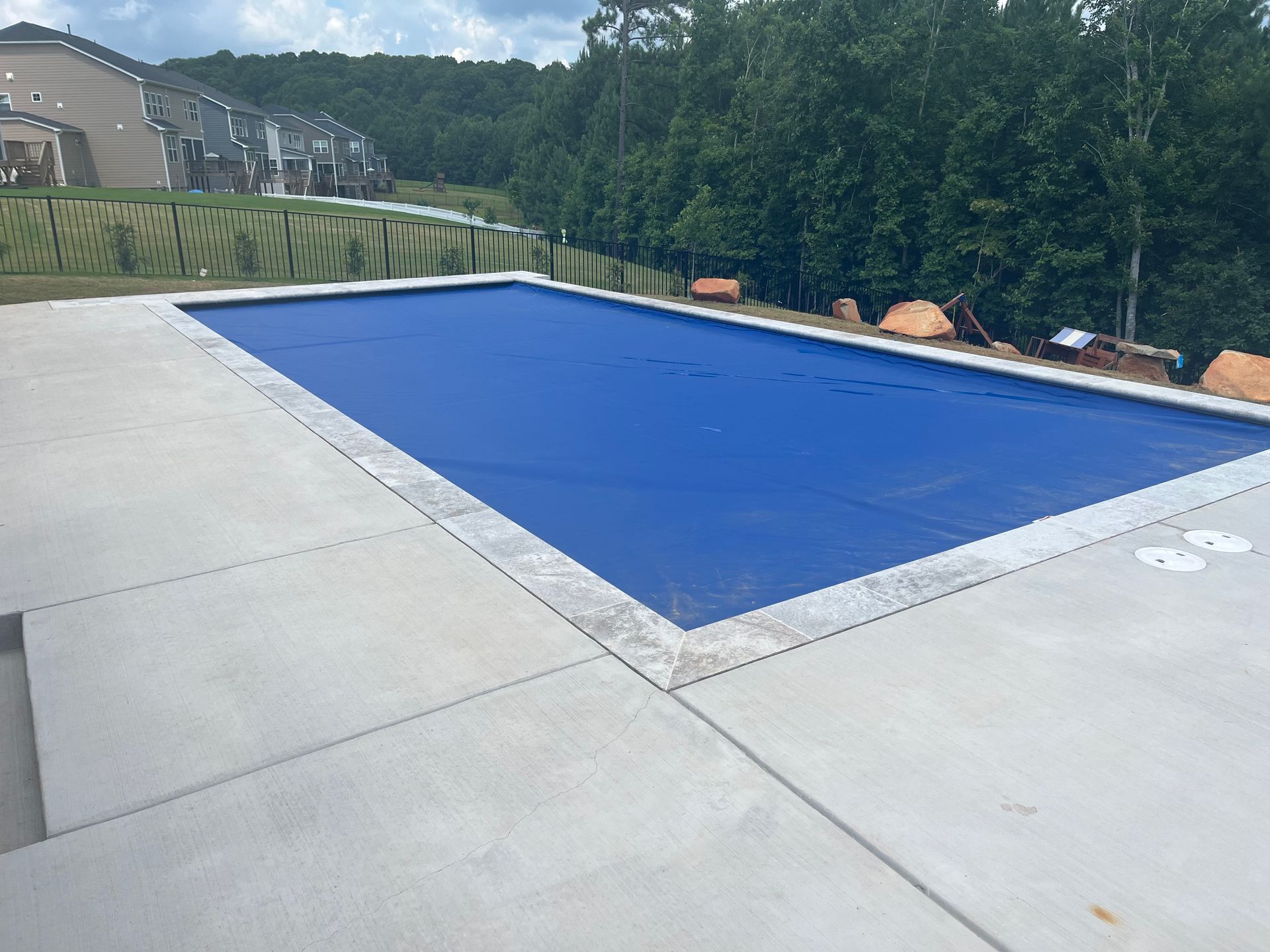 Blue pool with concrete surrounding it