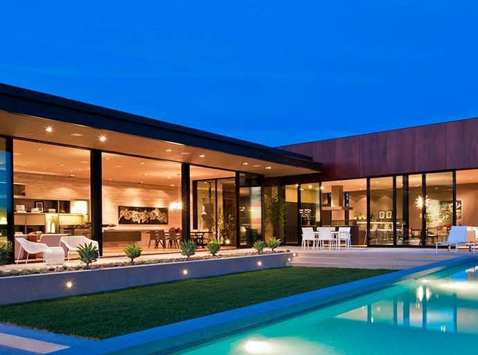 A large house with a swimming pool in front of it