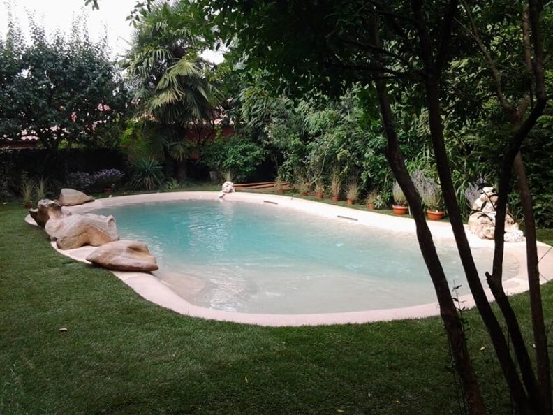 A large swimming pool surrounded by trees and grass