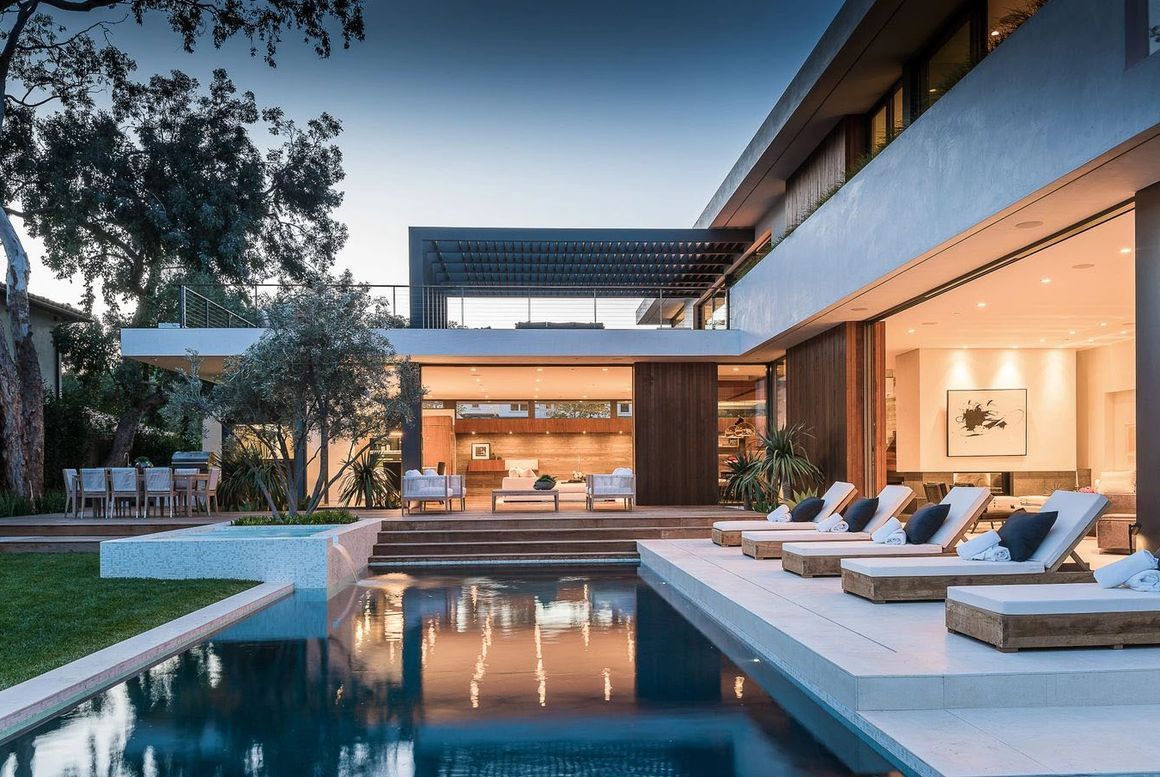 A large modern house with a swimming pool in the backyard.